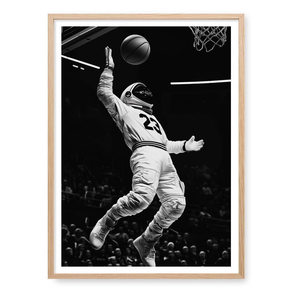 Low-angle action shot of an astronaut in a space suit and jersey number 23 performing a basketball dunk in a stadium, black and white art print titled Twenty Three in natural oak frame