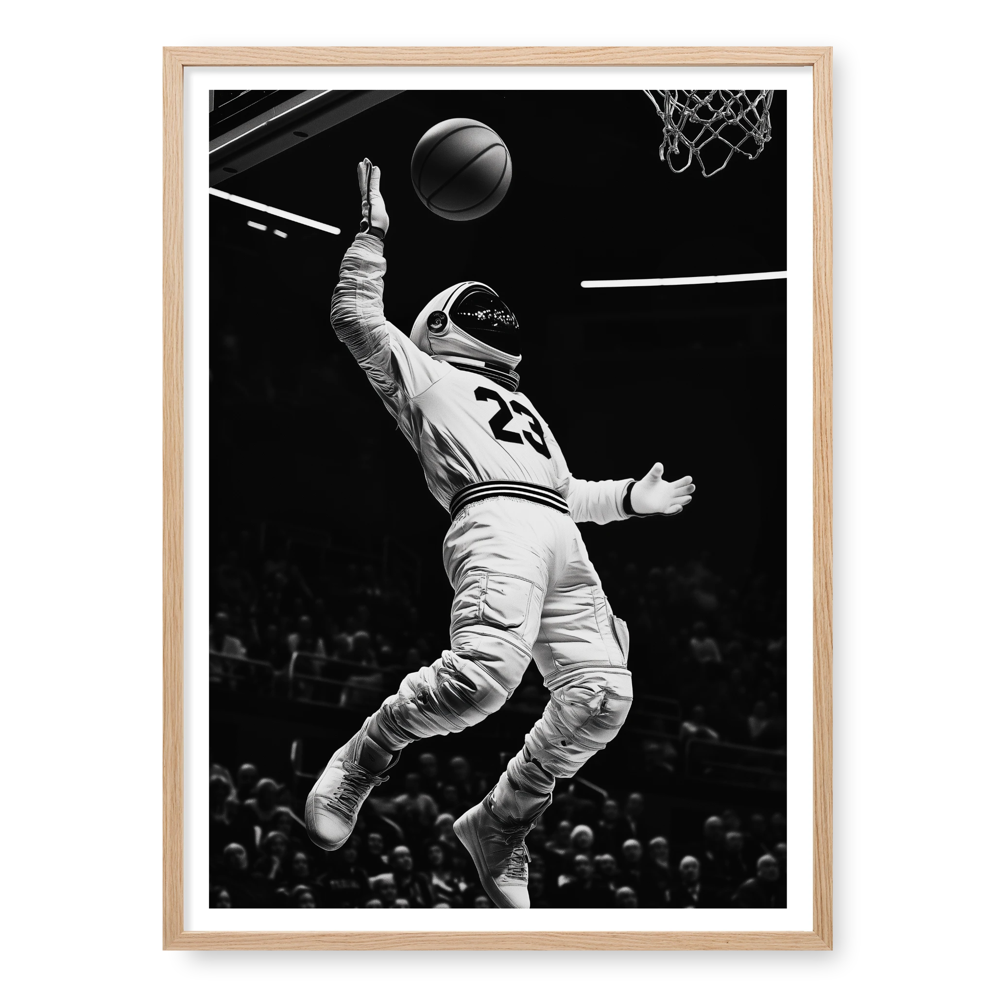 Low-angle action shot of an astronaut in a space suit and jersey number 23 performing a basketball dunk in a stadium, black and white art print titled Twenty Three in natural oak frame