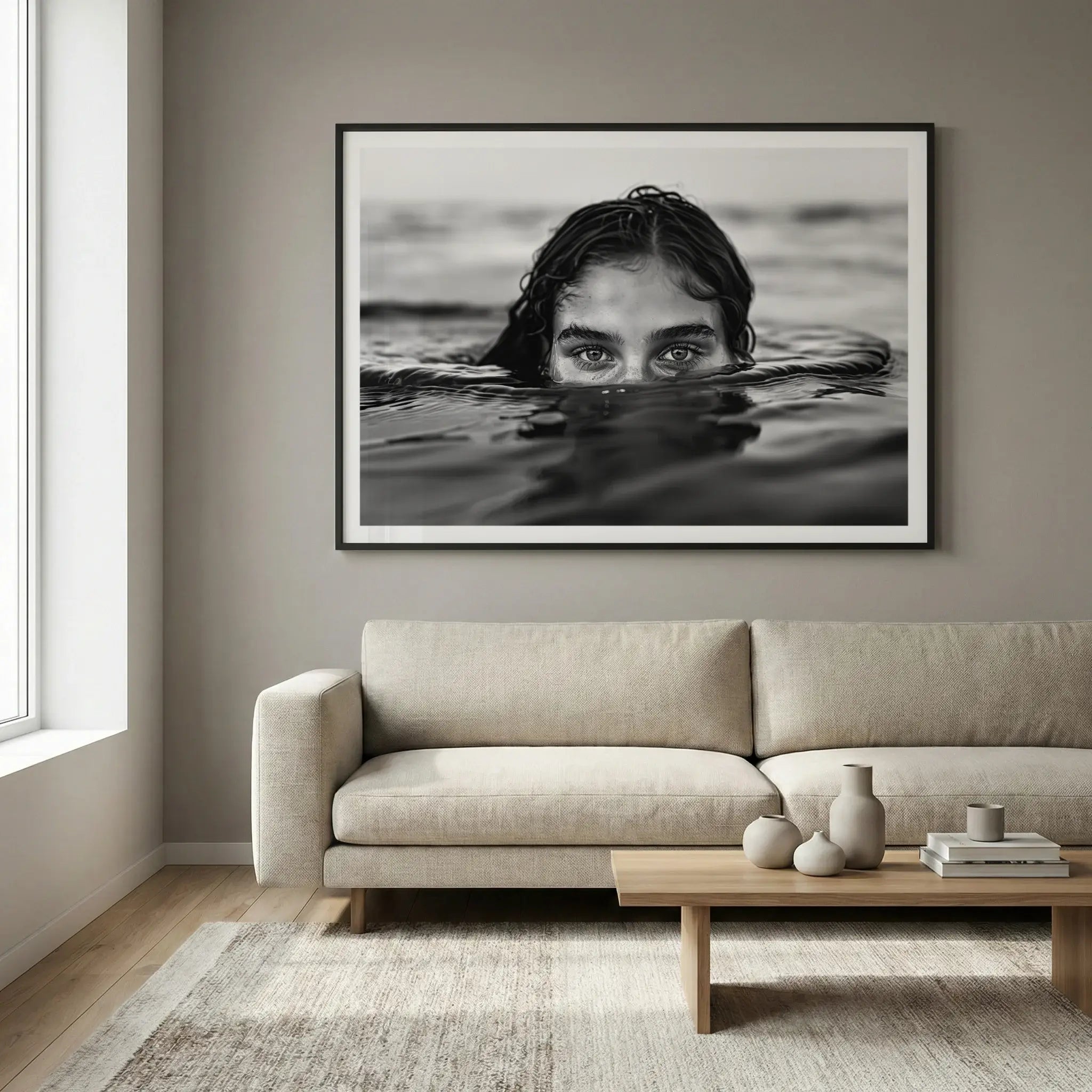 Framed black and white art print with woman partially submerged in calm water, titled Allure displayed in living room