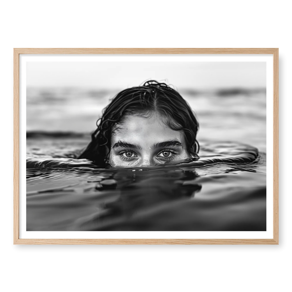 Woman partially submerged in calm water with eyes surfacing, black and white art print titled Allure in natural oak frame