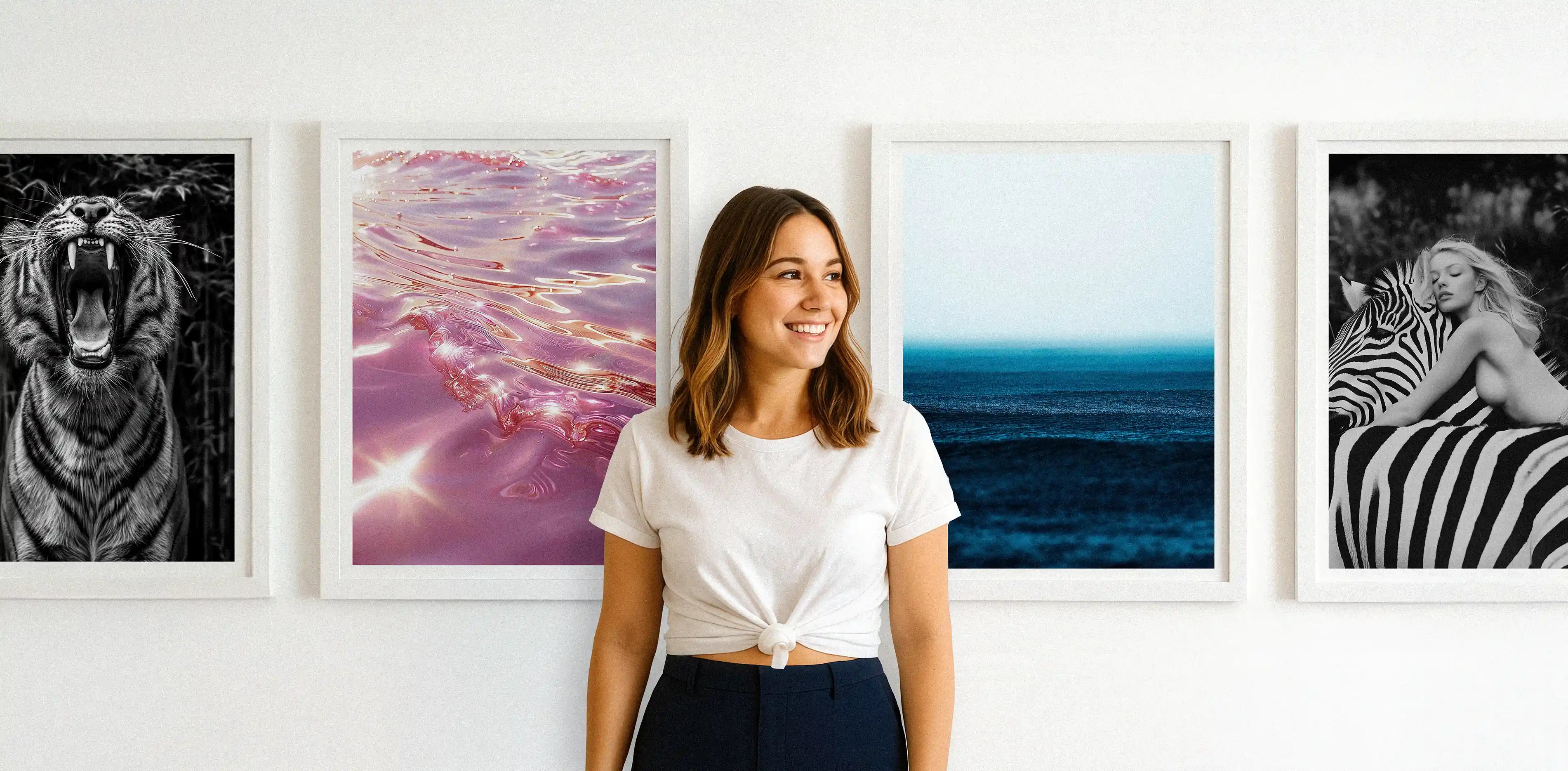 Founder of Blanc Studio standing in front of framed art prints in a gallery setting.