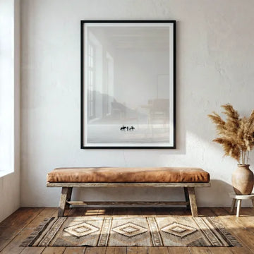 Minimal landscape artwork displayed above a wooden bench in a neutral room.