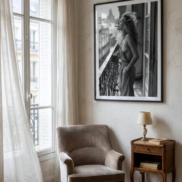 Black and white portrait artwork of a woman on a balcony, displayed in a calm bedroom.