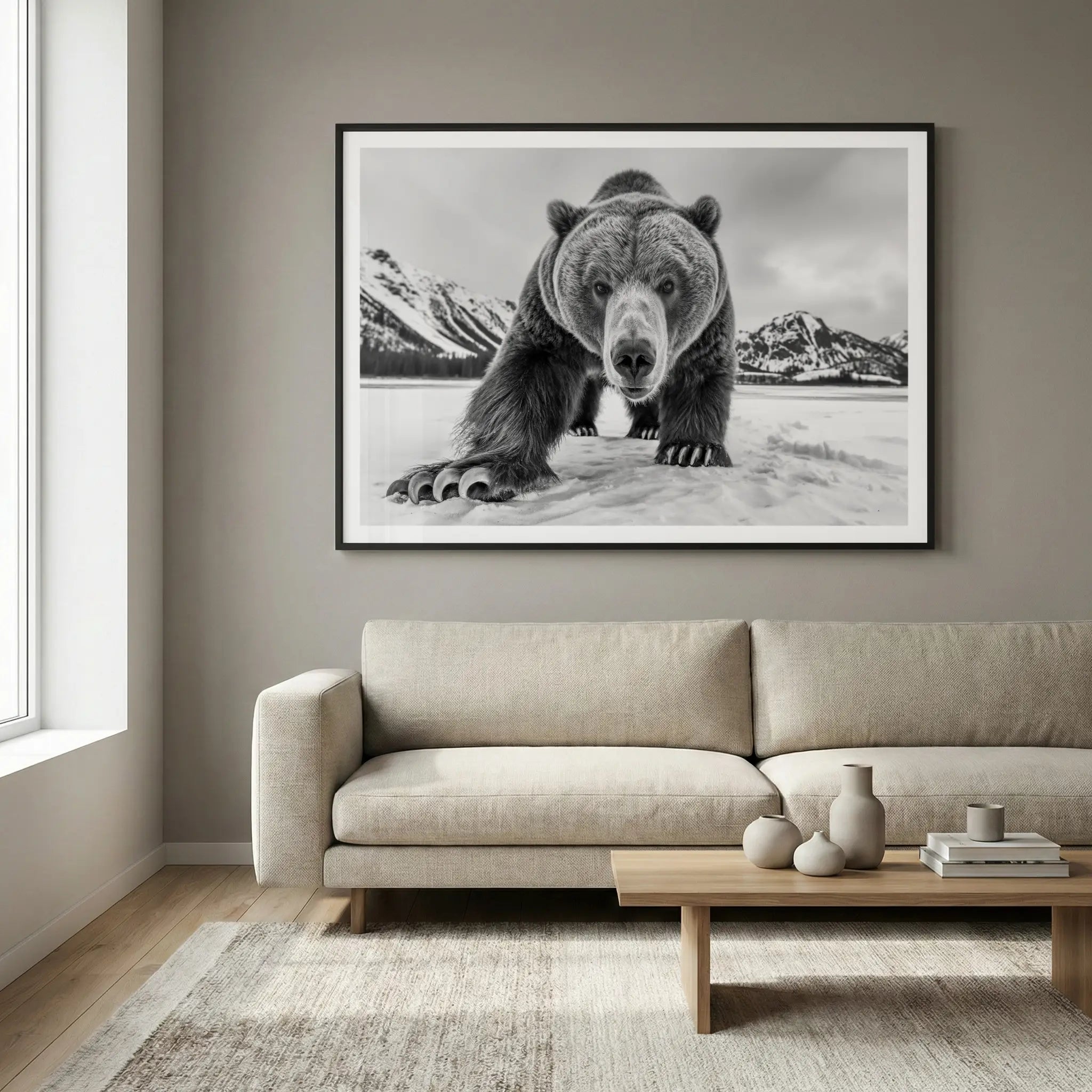 Framed black and white art print with grizzly bear approaching on snow, titled Curiosity displayed in living room