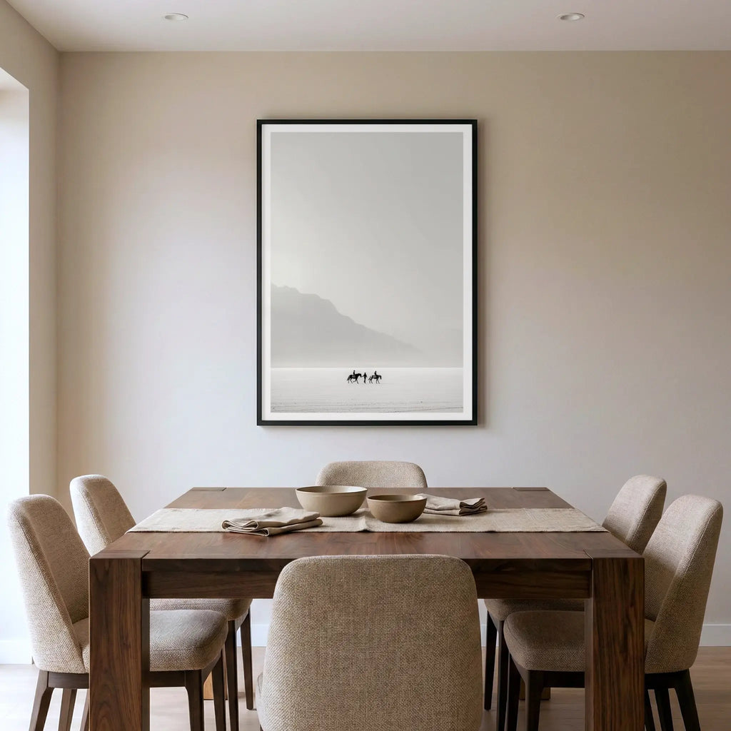 Framed minimalist art print with tiny riders on horseback in a white desert, titled Destination Unknown displayed in dining room