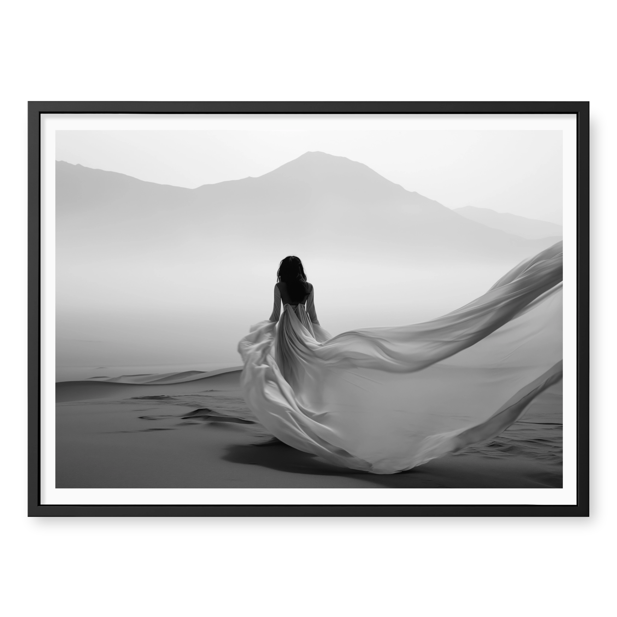 Rear view of woman in a long flowing dress walking across sand dunes towards misty mountains, black and white art print titled Freedom in black frame