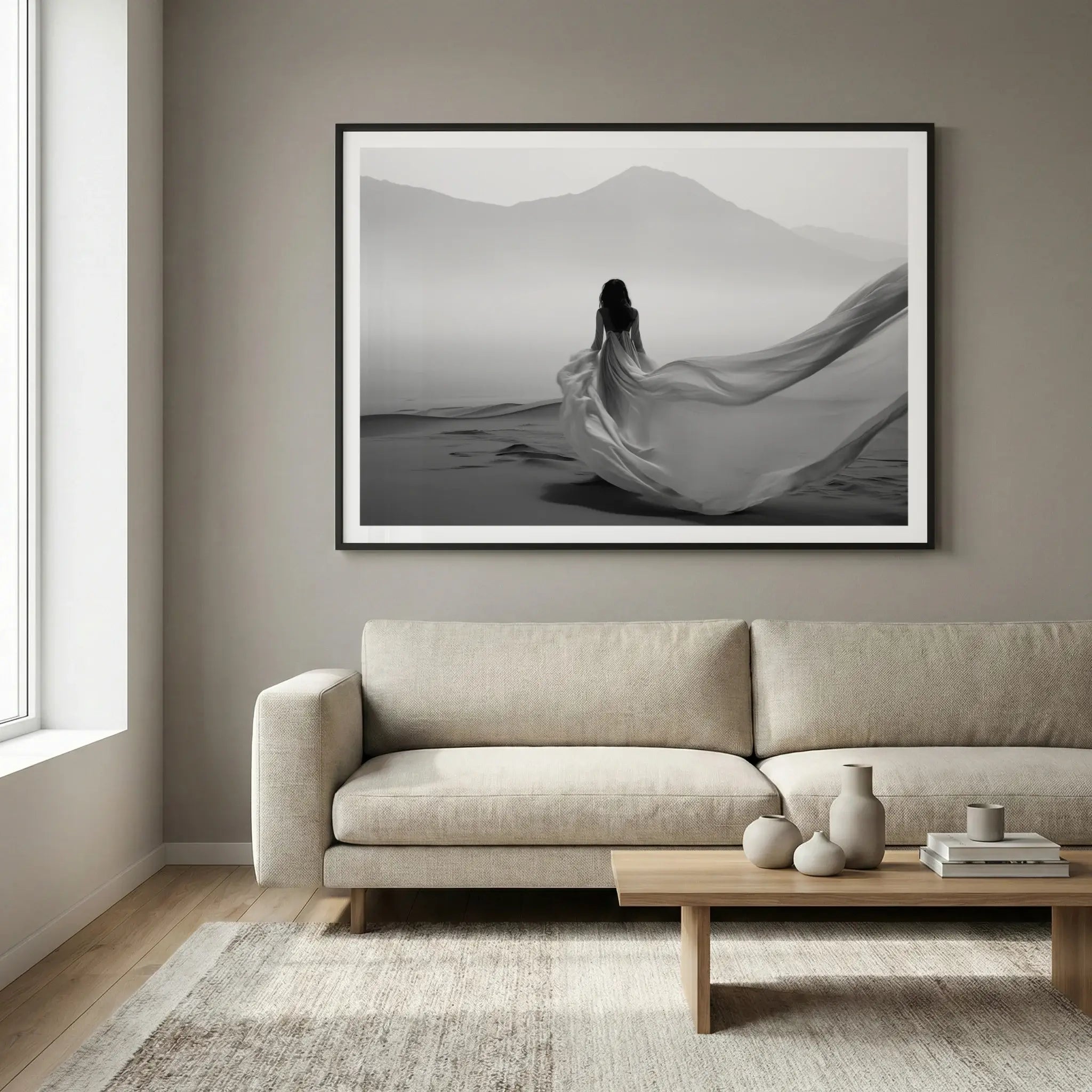 Framed black and white art print with woman in flowing dress walking in desert, titled Freedom displayed in living room