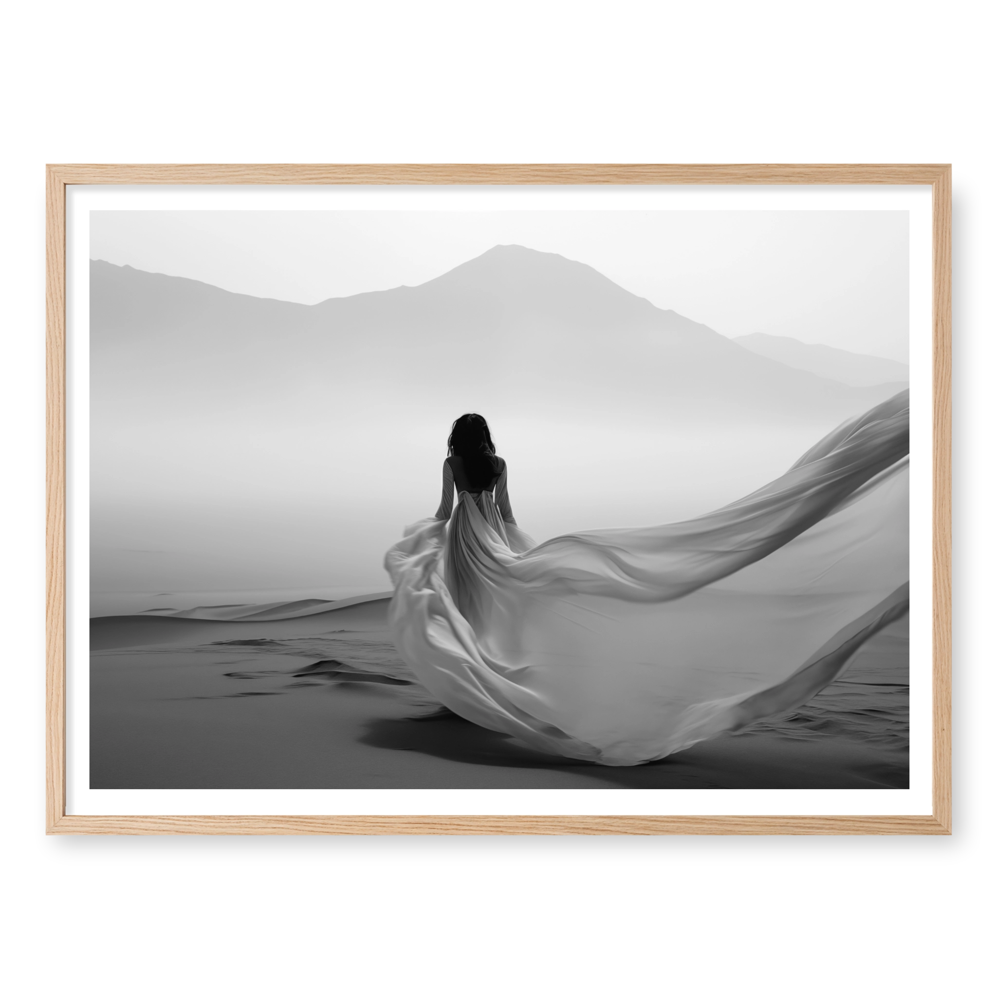 Rear view of woman in a long flowing dress walking across sand dunes towards misty mountains, black and white art print titled Freedom in natural oak frame