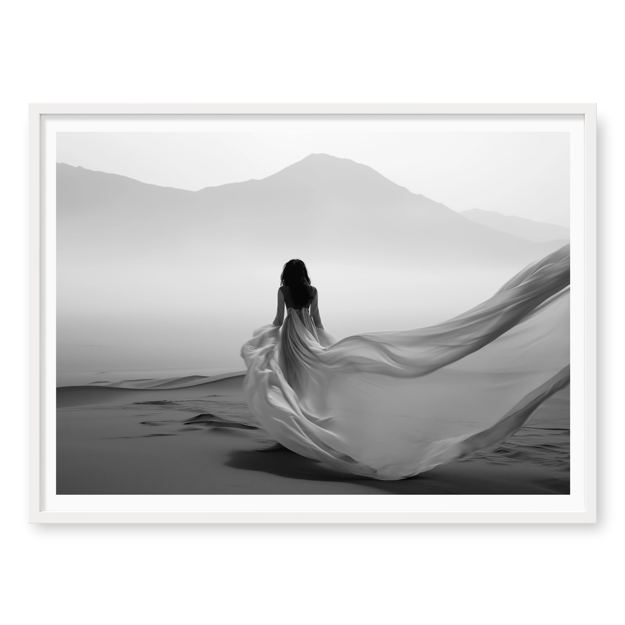 Rear view of woman in a long flowing dress walking across sand dunes towards misty mountains, black and white art print titled Freedom in white frame