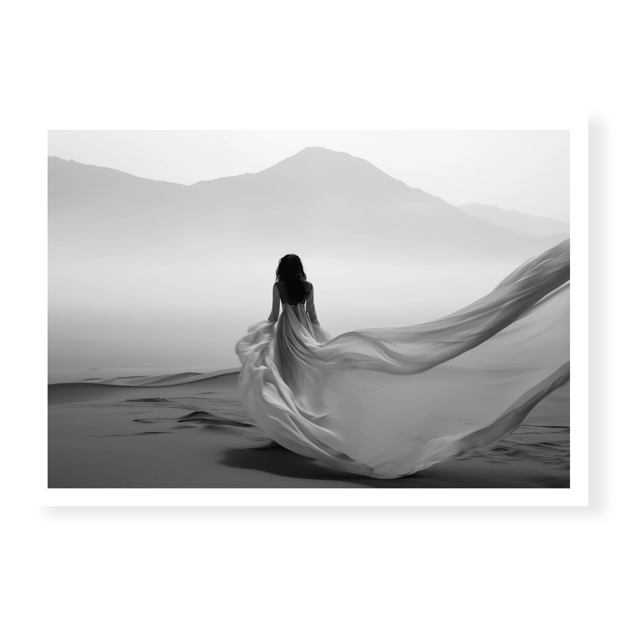 Rear view of woman in a long flowing dress walking across sand dunes towards misty mountains, black and white art print titled Freedom