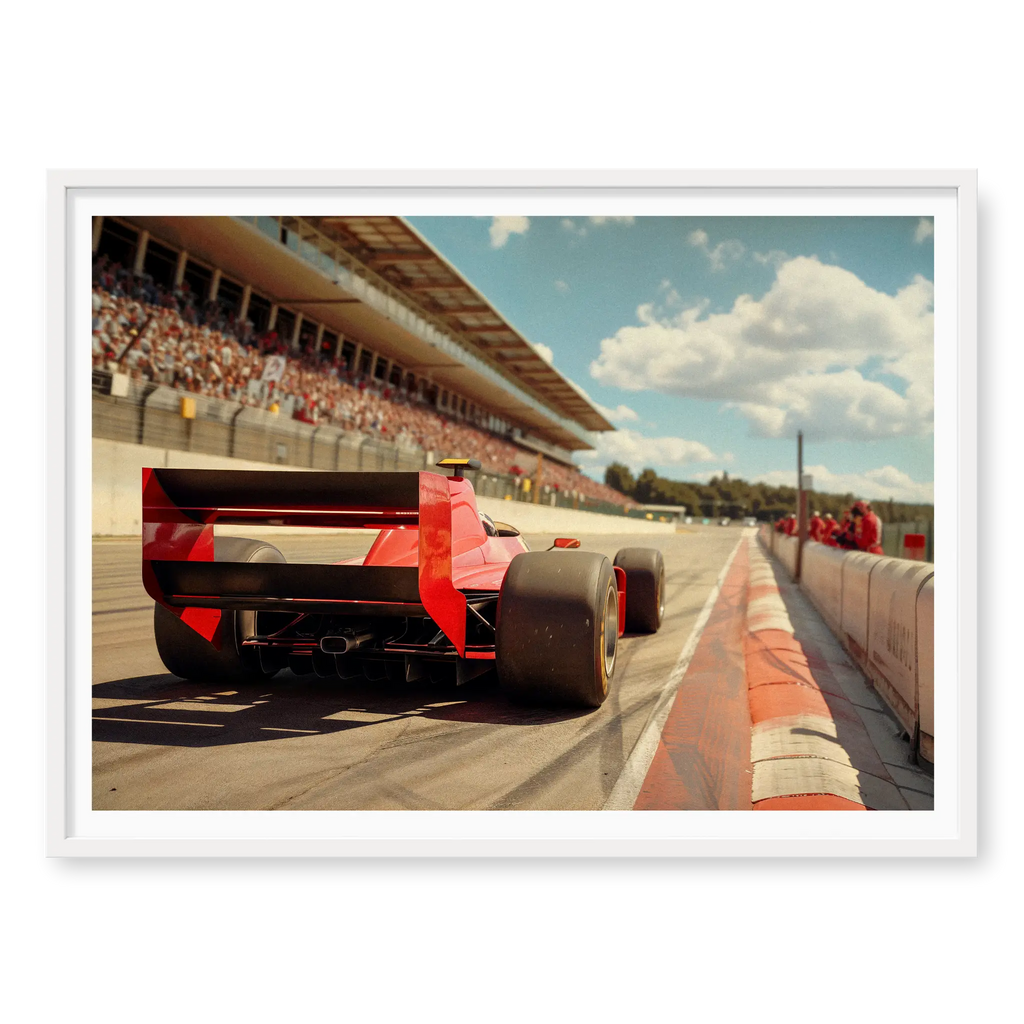 Low angle rear view of a vintage red F1 race car driving on a track with grandstands in the background, art print titled Glory Days in white frame