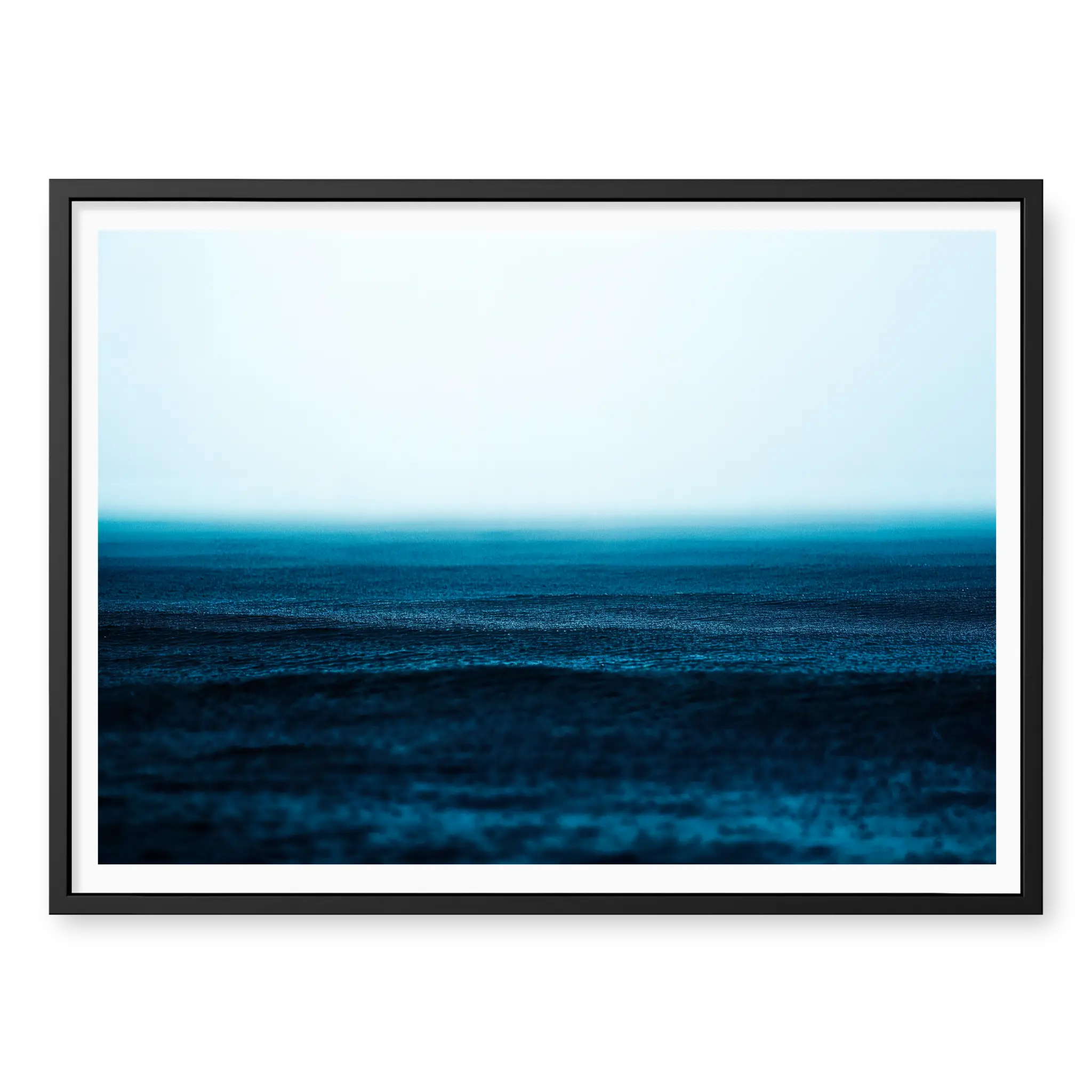 Minimalist seascape with deep blue water textured by falling rain fading into a misty white horizon, art print titled Petrichor in black frame