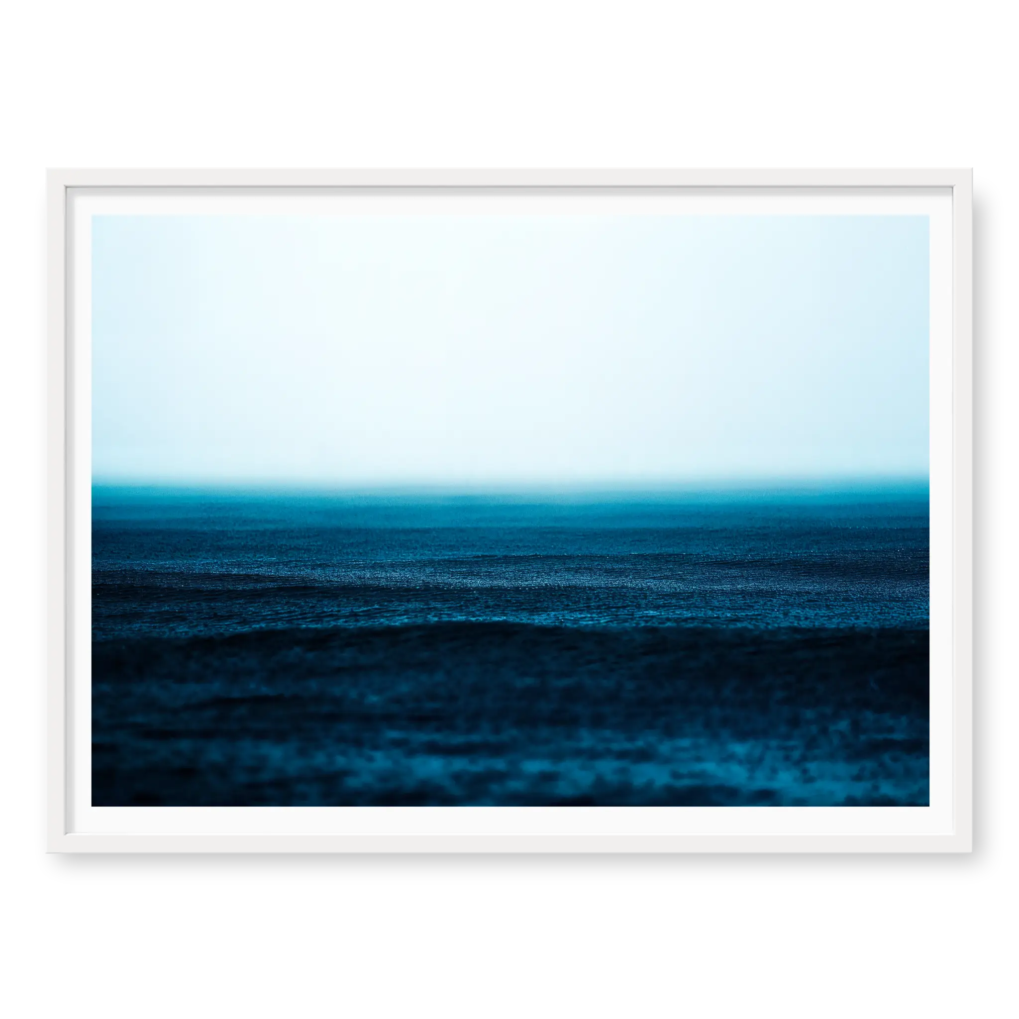 Minimalist seascape with deep blue water textured by falling rain fading into a misty white horizon, art print titled Petrichor in white frame