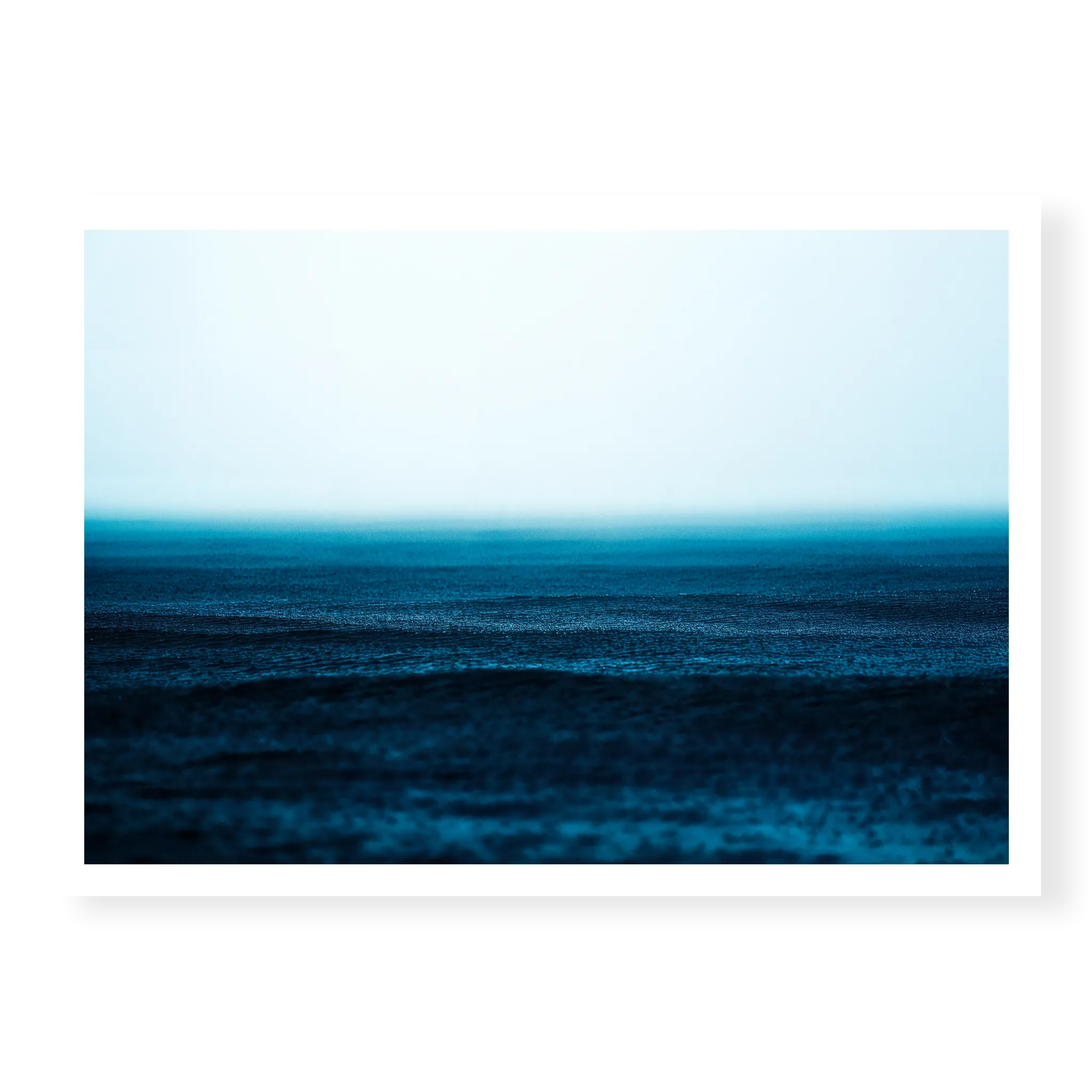 Minimalist seascape with deep blue water textured by falling rain fading into a misty white horizon, art print titled Petrichor