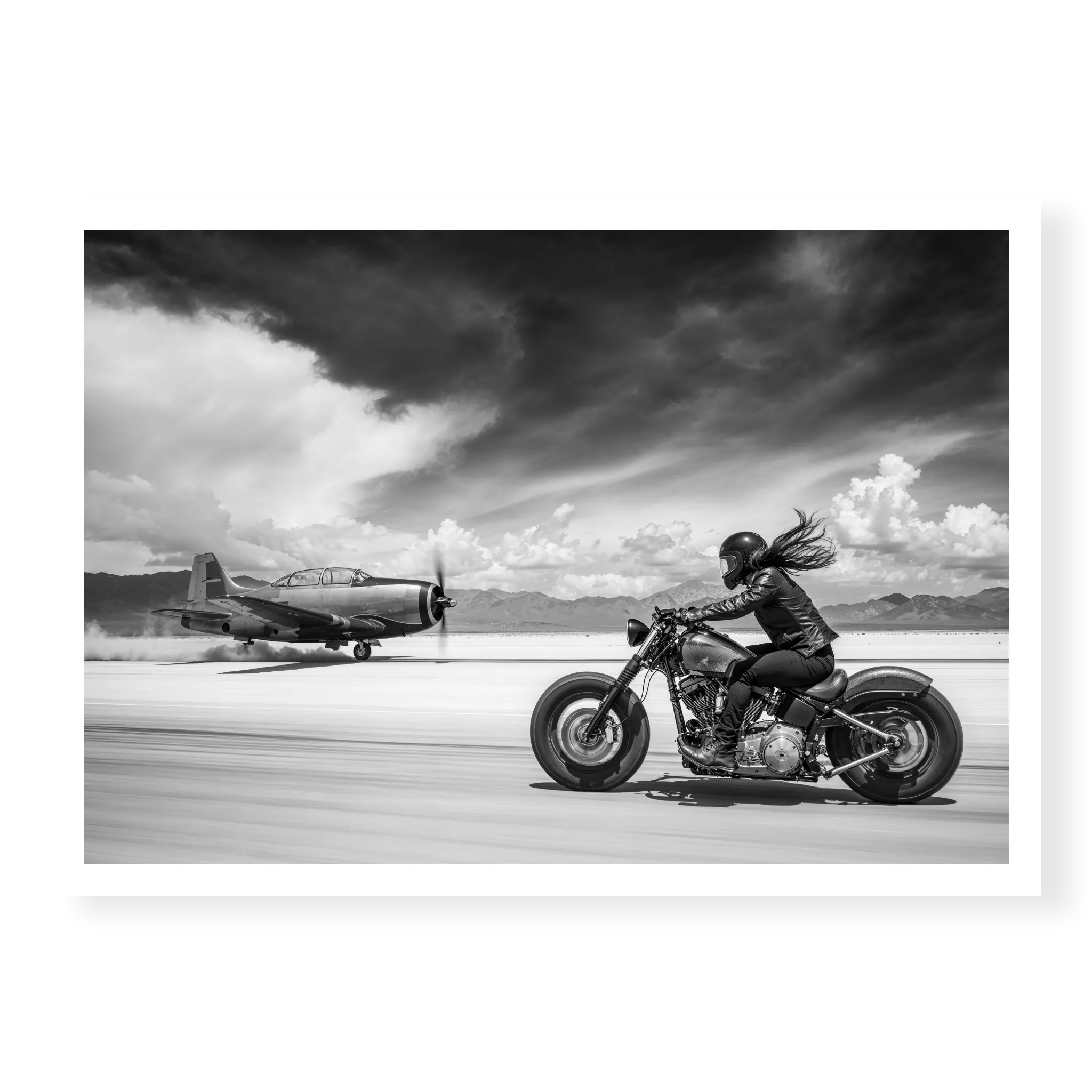 Side view of a rider on a motorcycle racing down a runway alongside a vintage propeller plane, black and white art print titled Ride or Die