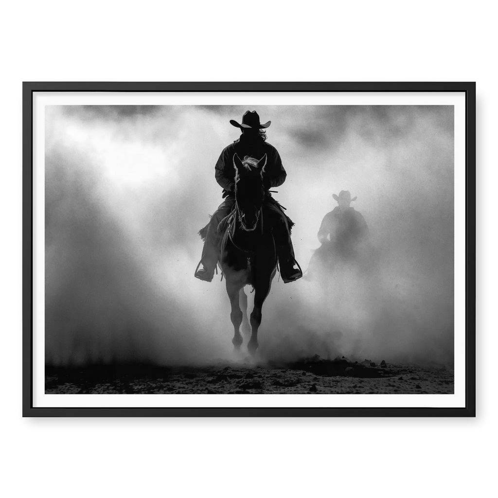 Silhouette of a cowboy riding a horse head-on through thick dust and fog, with a second rider fading into the background, black and white art print titled Searchers in black frame
