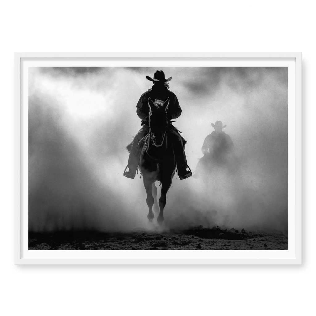 Silhouette of a cowboy riding a horse head-on through thick dust and fog, with a second rider fading into the background, black and white art print titled Searchers in white frame