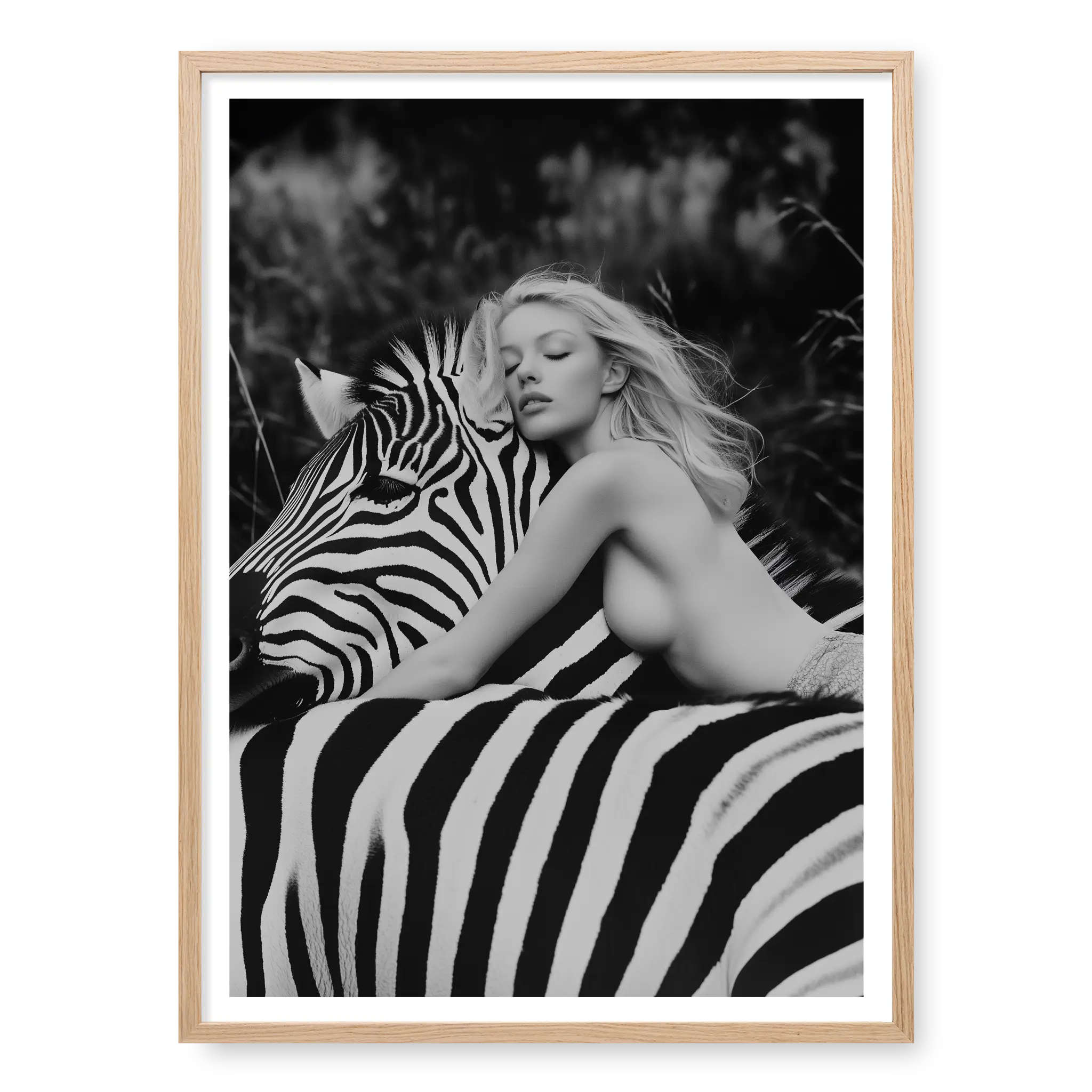 Close-up black and white fine art print of a blonde woman leaning forward with her head resting gently on the neck of a zebra, titled Stripes in natural oak frame