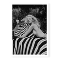 Close-up black and white fine art print of a blonde woman leaning forward with her head resting gently on the neck of a zebra, titled Stripes