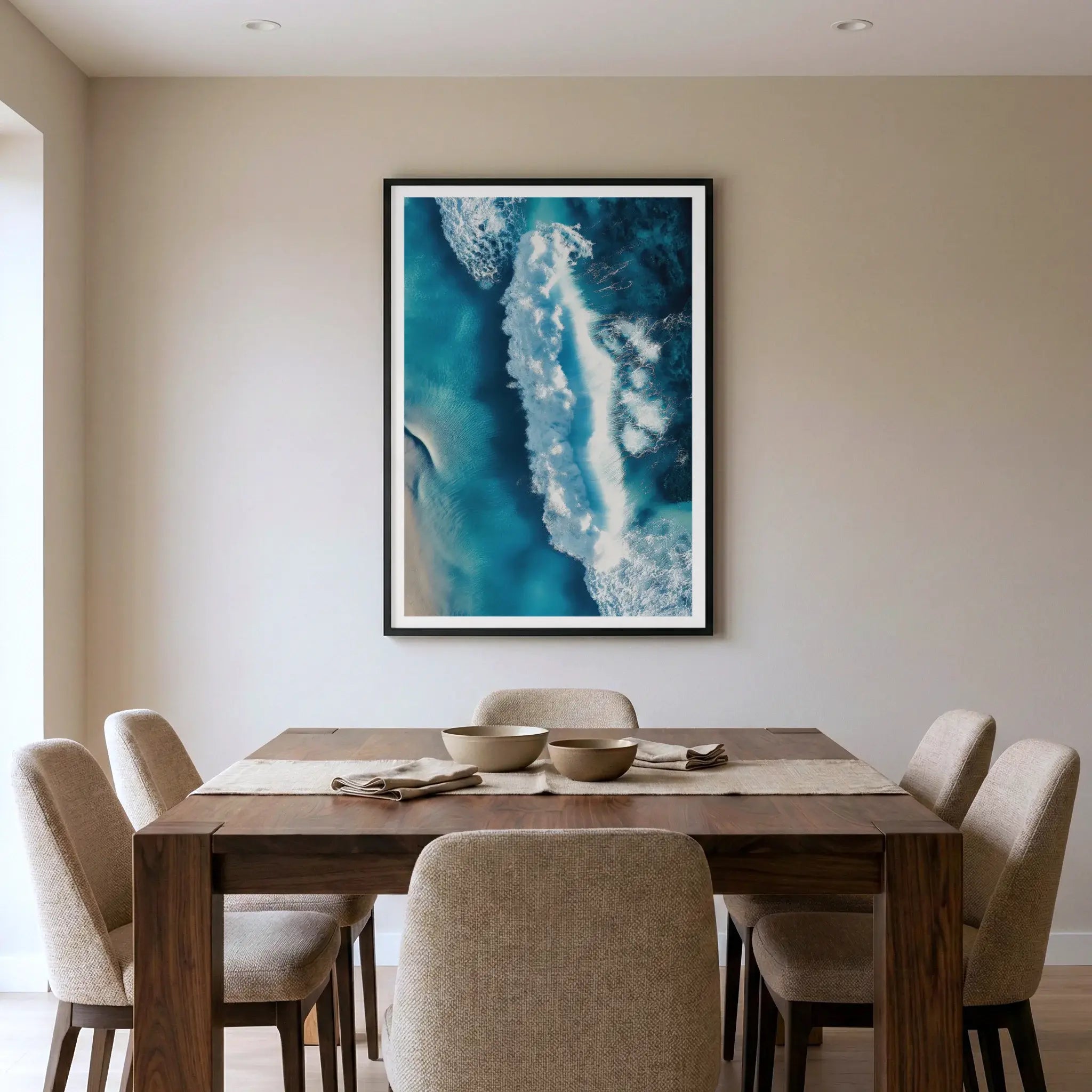 Framed aerial ocean art print with crashing wave, titled Terra Mater displayed in dining room
